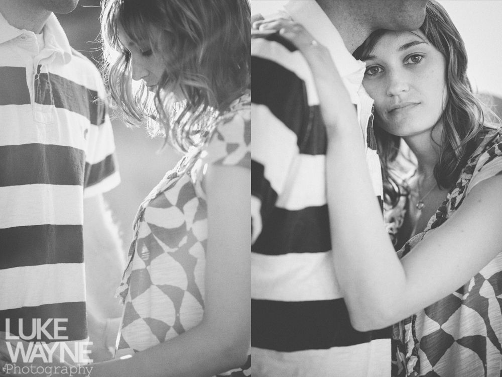 Couple embracing, black and white. Woman looks at the camera, man in striped shirt.