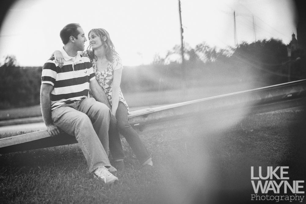 Couple seated, looking at each other. Sunlight flares.