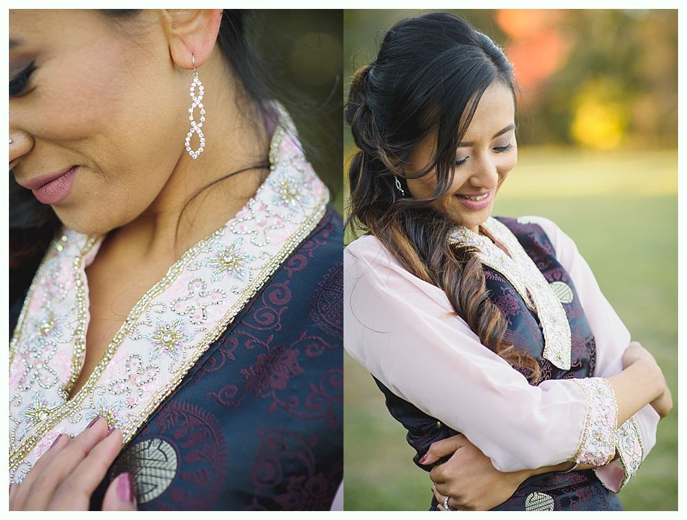 Woman in traditional embroidered attire, looking down. Outdoor setting, soft focus.
