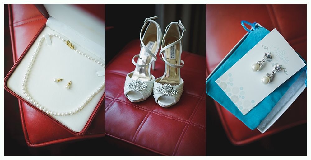 Wedding details: pearl necklace and earrings in a box, jeweled heels, and pearl earrings on a card, all on a red leather surface.