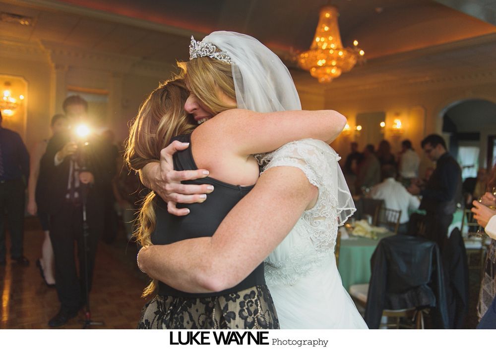 Wedding reception with dancing; bride in a white gown and guests in colorful dresses on a dance floor.
