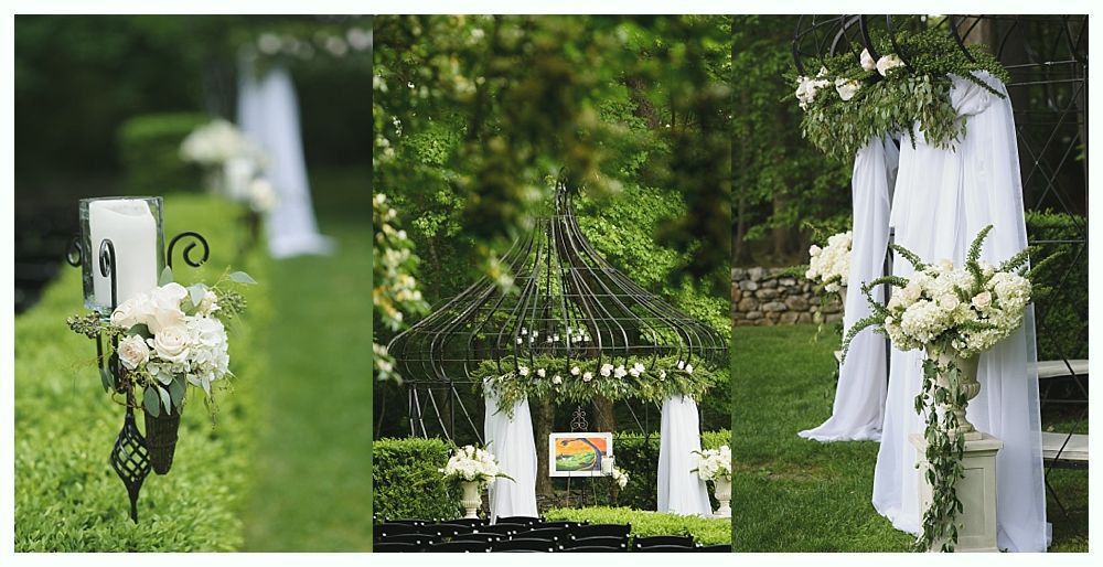 Wedding ceremony decorations: white flowers, draped fabric, black ironwork, and a gazebo on a lawn.