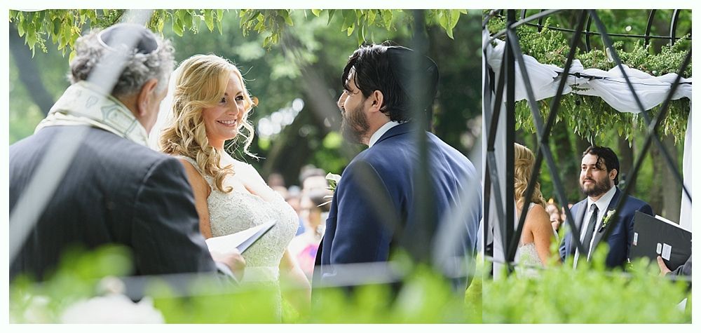 Bride and groom at outdoor wedding ceremony. Smiling, they are framed by foliage and a tent structure.