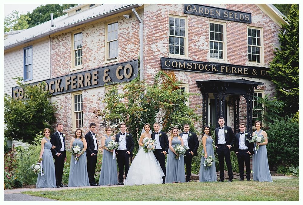Wedding party poses in front of historic brick building with signage,