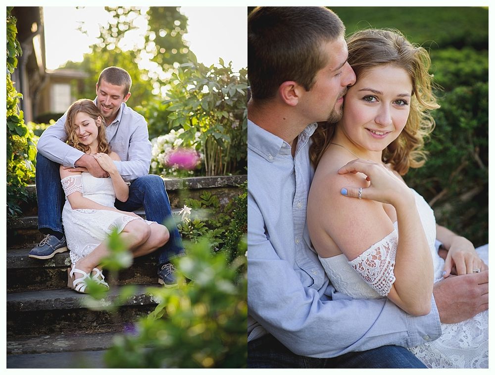Couple cuddling outdoors; woman in white dress, man kisses her cheek, seated on stone steps.