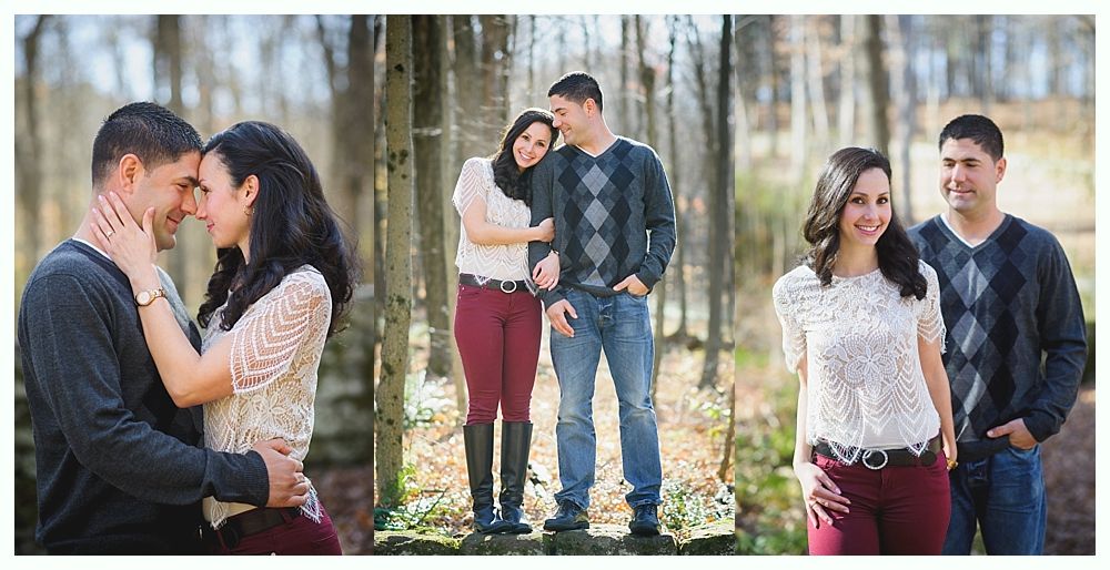 Couple in forest, embracing, smiling. Man in blue sweater, woman in lace top and burgundy pants.