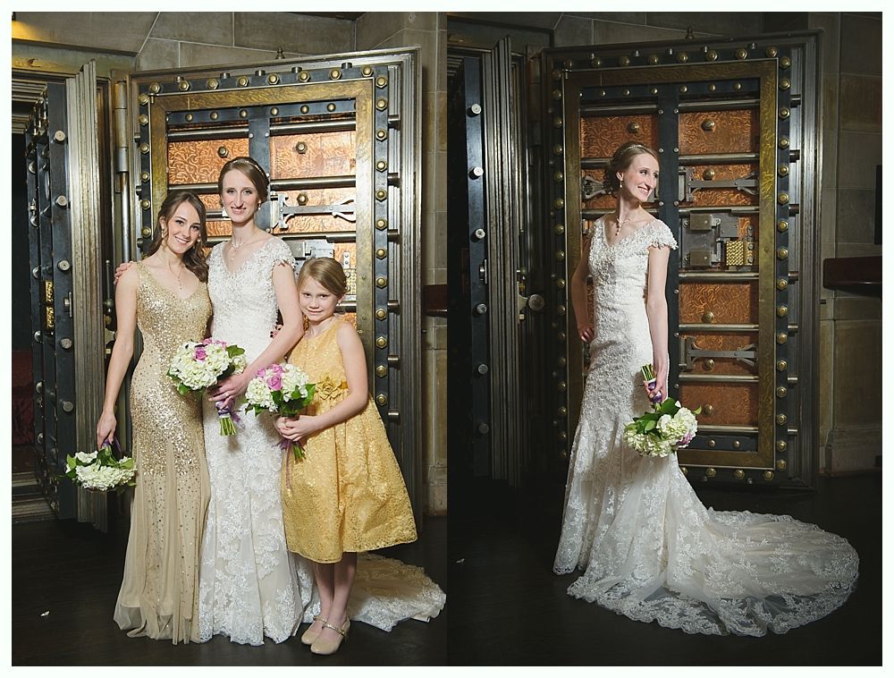 Bride with bridesmaids in front of bank vault doors, holding bouquets.