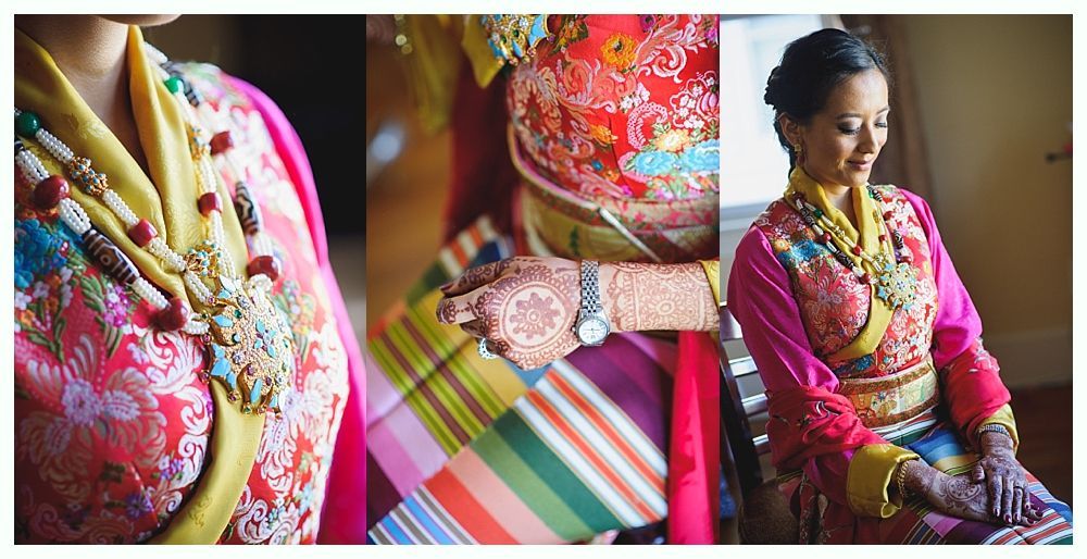 Woman in traditional multi-colored clothing with ornate jewelry, hennaed hands.
