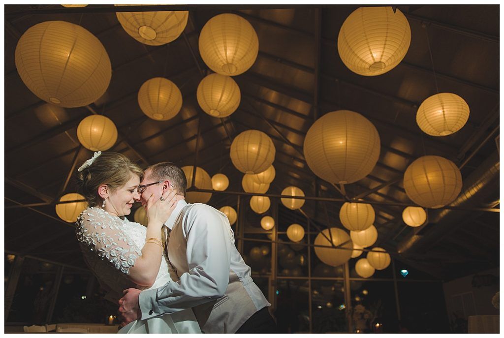 Couple embracing under glowing paper lanterns.