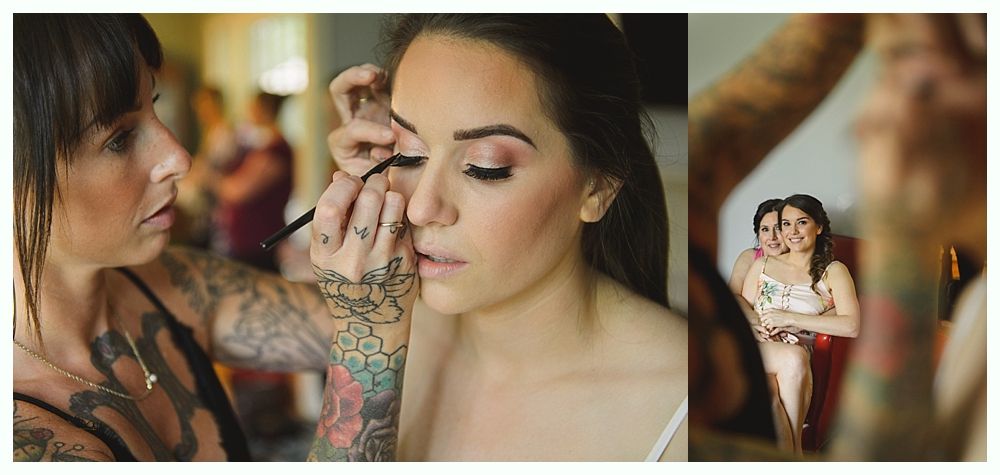 Makeup artist applying eyeliner on a woman in a bright room, another woman in mirror.