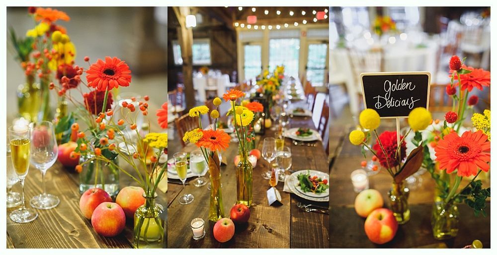 Long wooden table decorated with bright flowers and fruit, set for a wedding reception.
