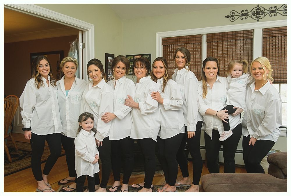 Group of women and children in oversized white shirts and black leggings, posing indoors.