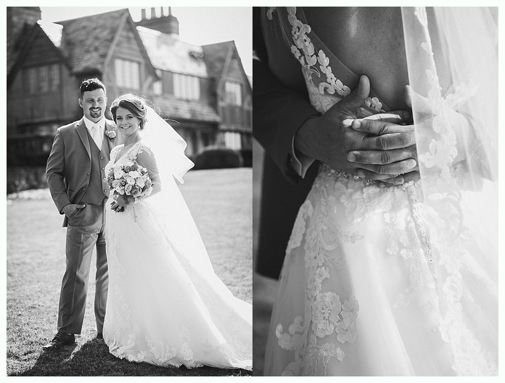 Wedding couple posing outside large building; close-up of groom's arms around bride's waist. Black and white.