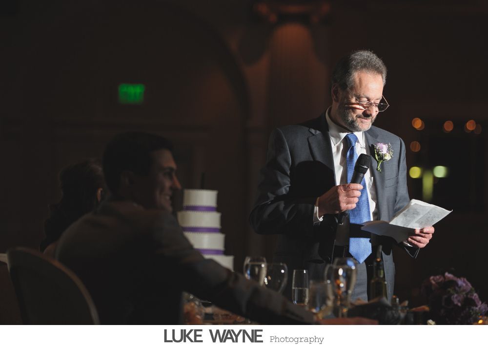Wedding reception details: cake, flowers, wine, purple and white decor.