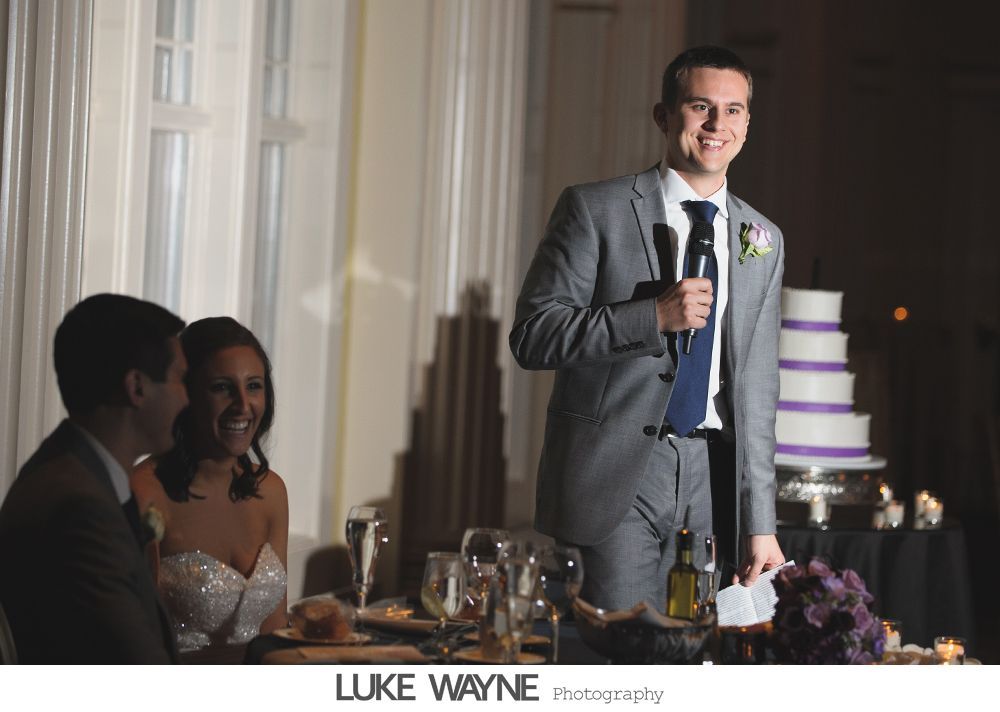 Wedding reception details: cake, flowers, wine, purple and white decor.