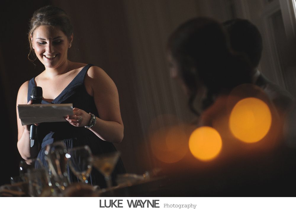 Wedding reception details: cake, flowers, wine, purple and white decor.