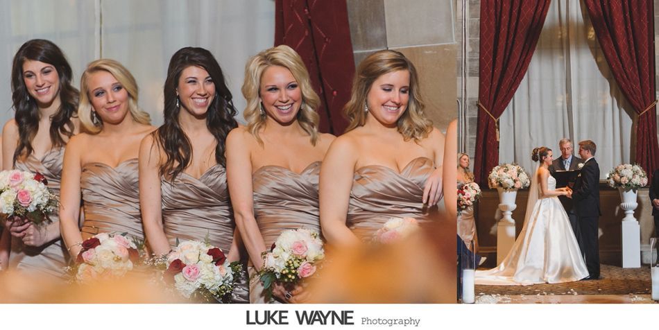 Bridesmaids in tan gowns with bouquets watch the bride and groom exchange vows in an elegant room.