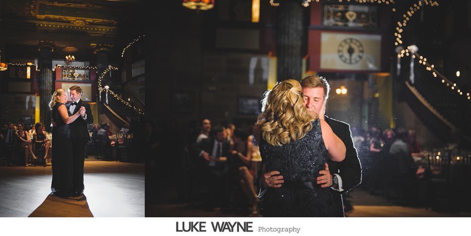 Couple dancing at a wedding reception; a dark, decorated venue with string lights.