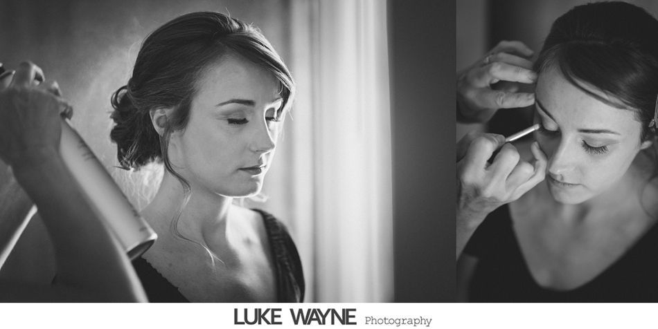 Woman having her hair styled and makeup applied before an event; black and white photo.