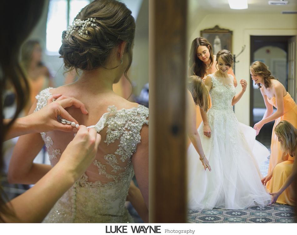 Bride in wedding dress, being helped by bridesmaids, buttoning dress and adjusting the train.