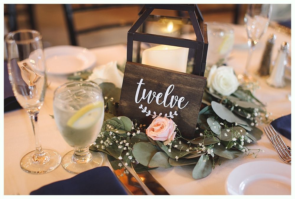 Wedding table setting with centerpiece: black lantern, floral wreath, 