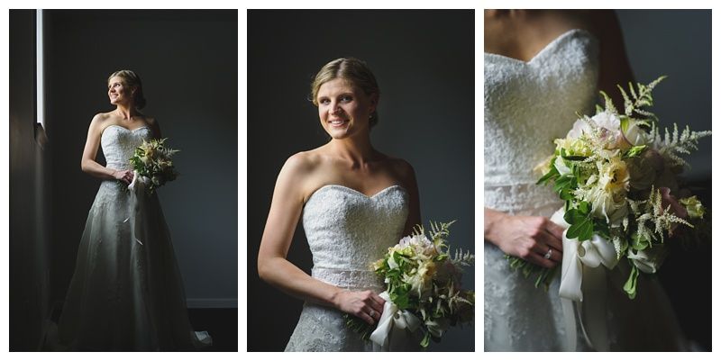 Bride with arms up, making a funny face, groom looking at his hand, cake cutting in background.