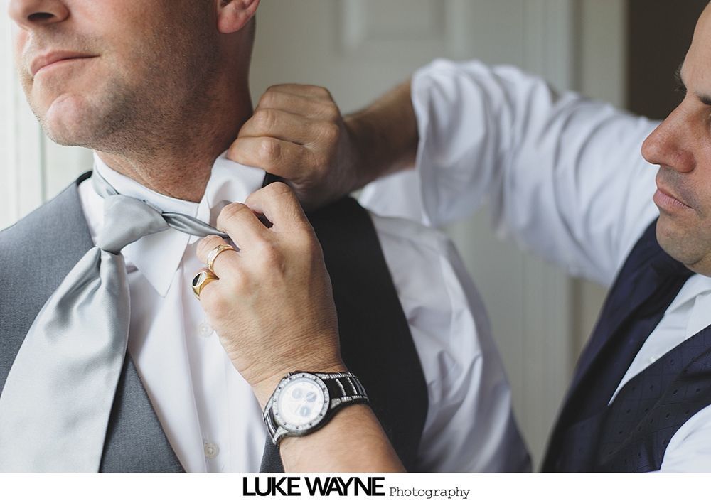 Wedding details: brown leather bracelet with earrings, book with bracelet, white heels.