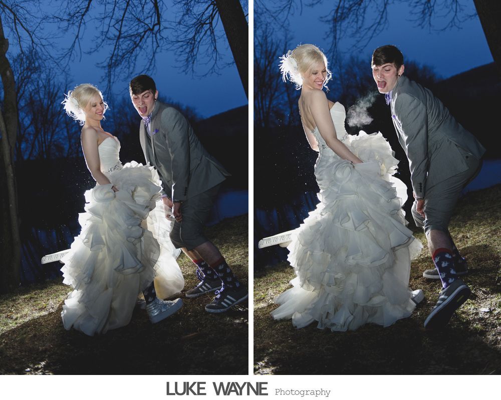 Wedding couple, in formal attire, playfully kicks up dress. Outdoor setting, at night.