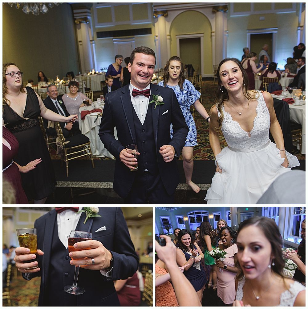 Wedding reception: couple and guests dancing, man holding drinks, in ballroom.