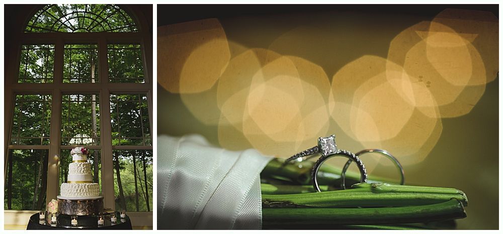 Wedding cake in a window, diamond rings on a green surface with bokeh lights in the background.