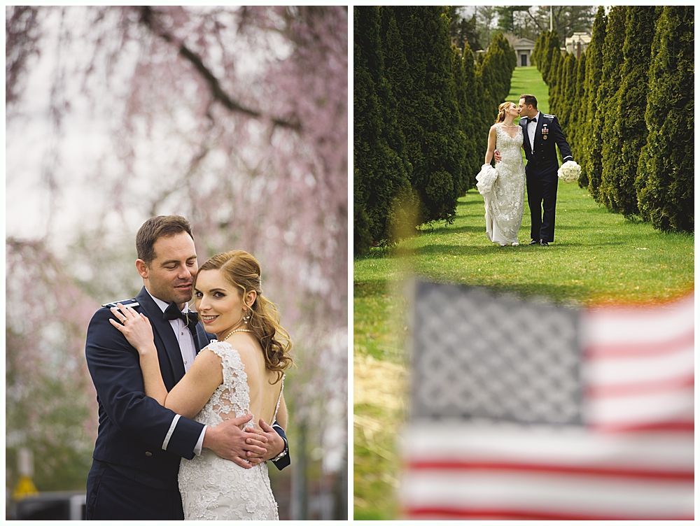 Wedding couple poses outdoors, embracing. In the distance, they walk a path lined with trees, near an American flag.