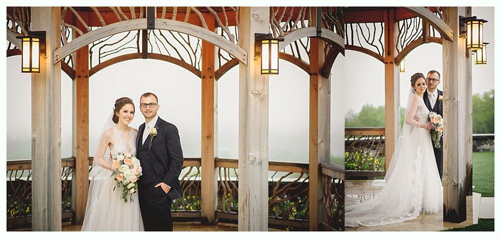 Bride and groom pose for photos under a wooden arbor, smiling.