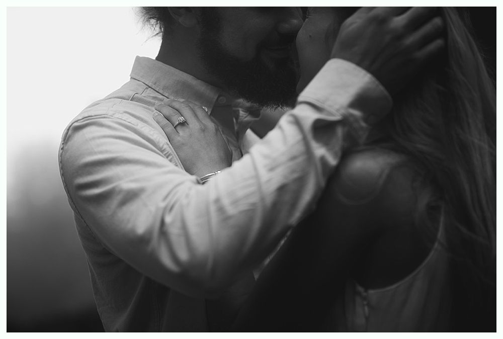 Man in white shirt embracing someone with blonde hair, kissing.
