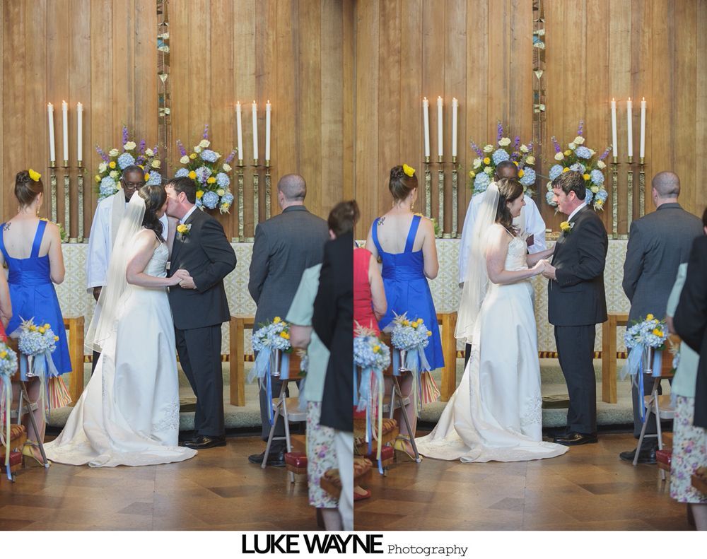 Wedding couple embracing on a rural road; the bride wears a white dress and veil, the groom in a suit and vest.