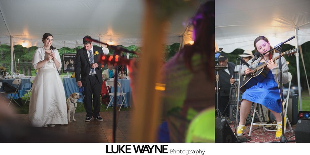 Group photo at a wedding reception. Bride and groom centered, surrounded by guests in formal attire.