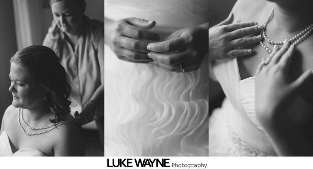 Bride getting ready, necklace adjusted, ruffled dress detail. Black and white.
