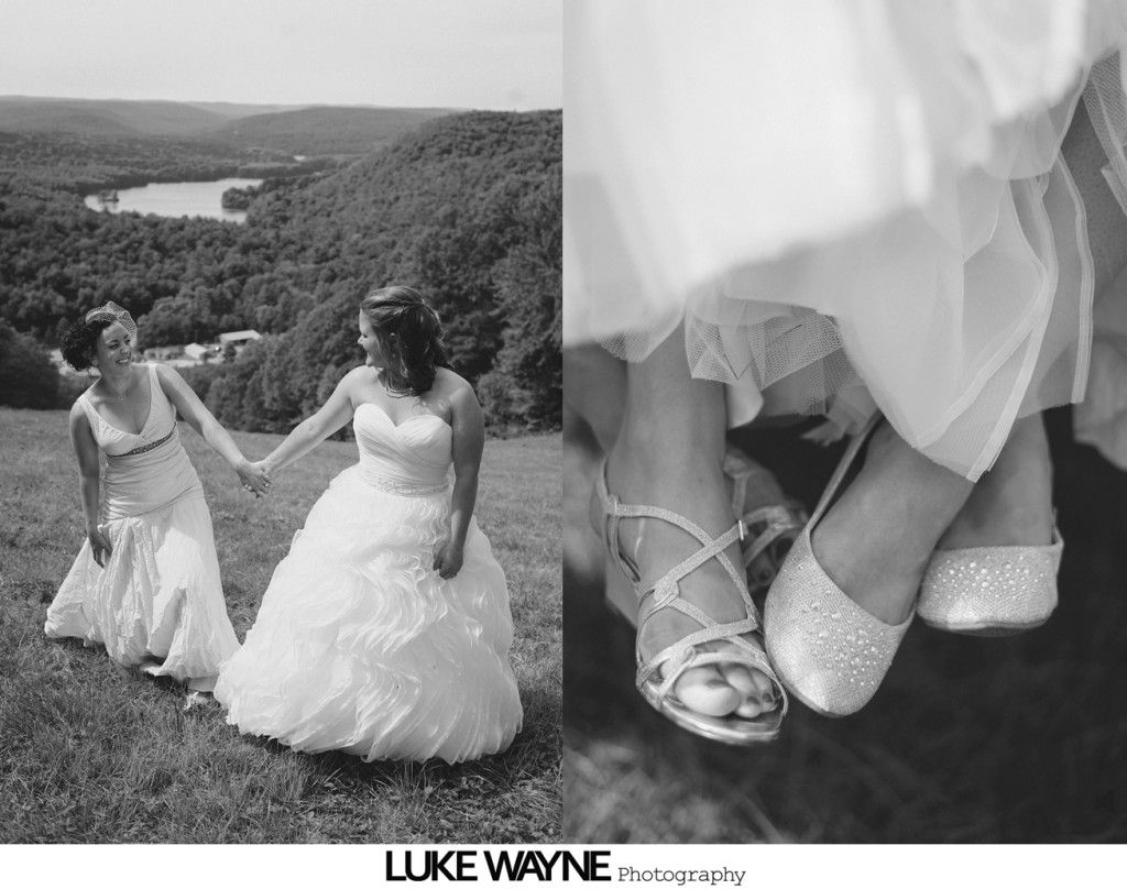 Two brides holding hands on a hill overlooking a lake. Close-up of sparkly shoes.