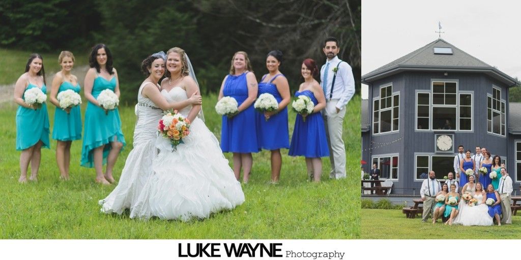 Wedding party with two brides in front of a blue building, on a green lawn.