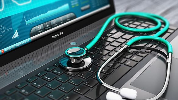 A stethoscope is sitting on top of a laptop computer.