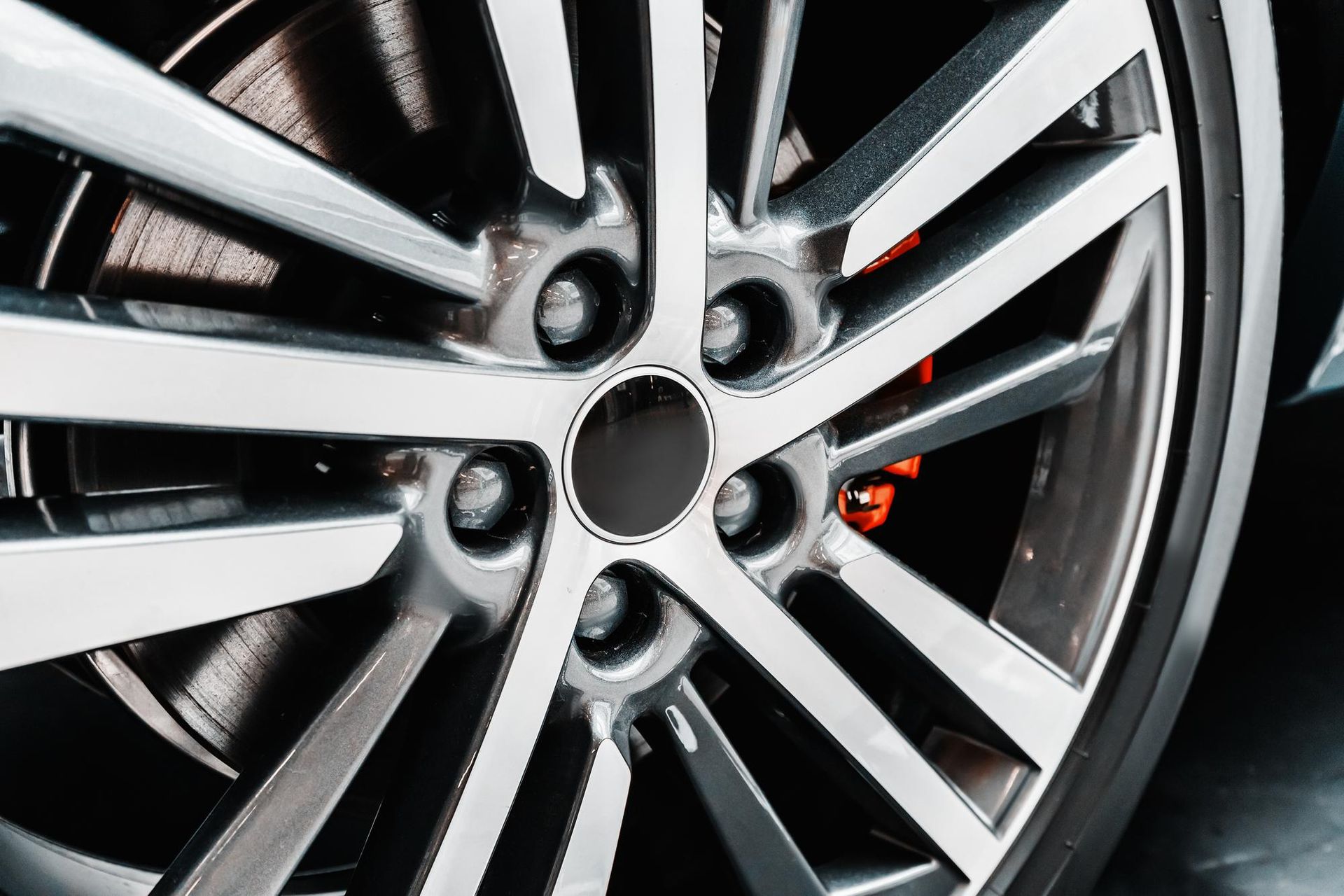 Close-up of a shiny silver car wheel with a red brake caliper.