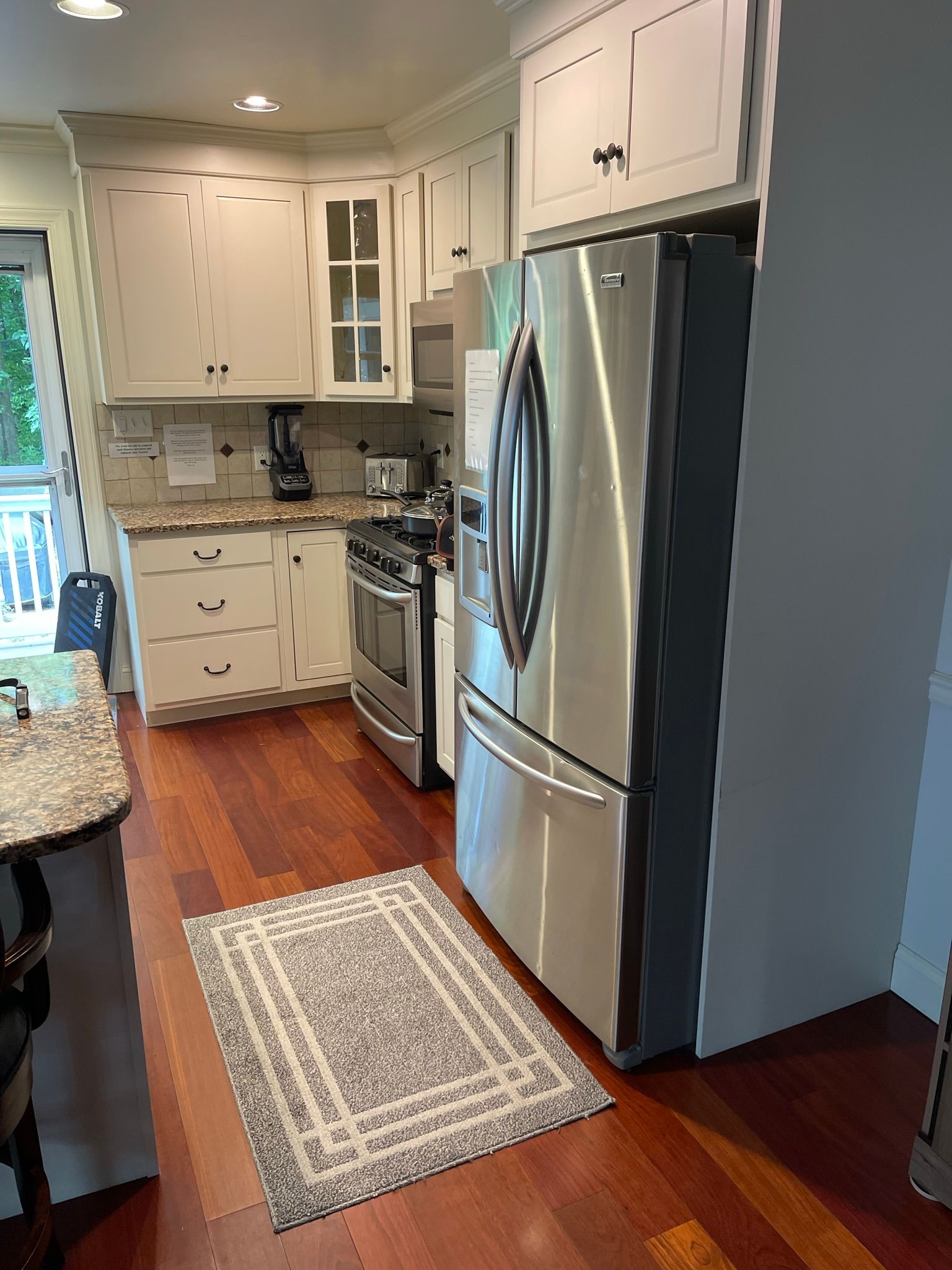 A kitchen with stainless steel appliances and white cabinets