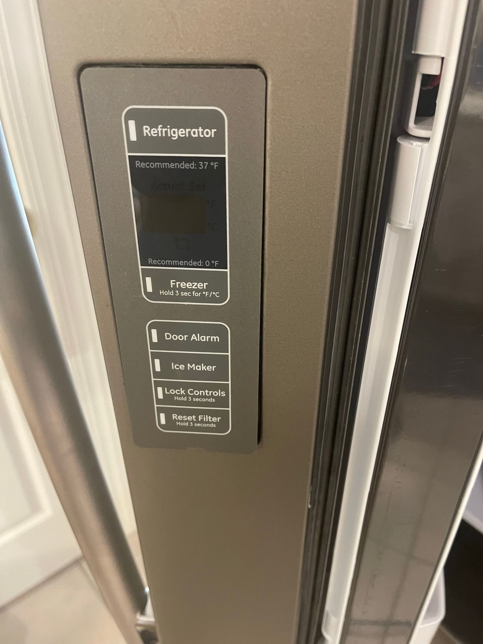 A stainless steel refrigerator with a digital display on the door.