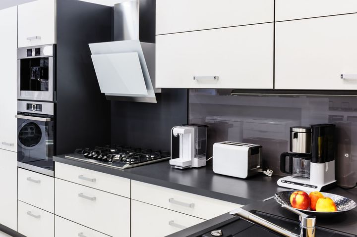 A kitchen with white cabinets and stainless steel appliances