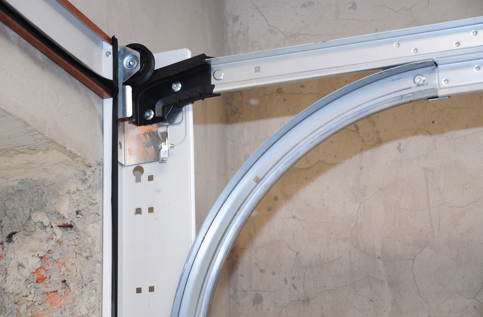 Garage door track and roller assembly, showing curved and straight sections.