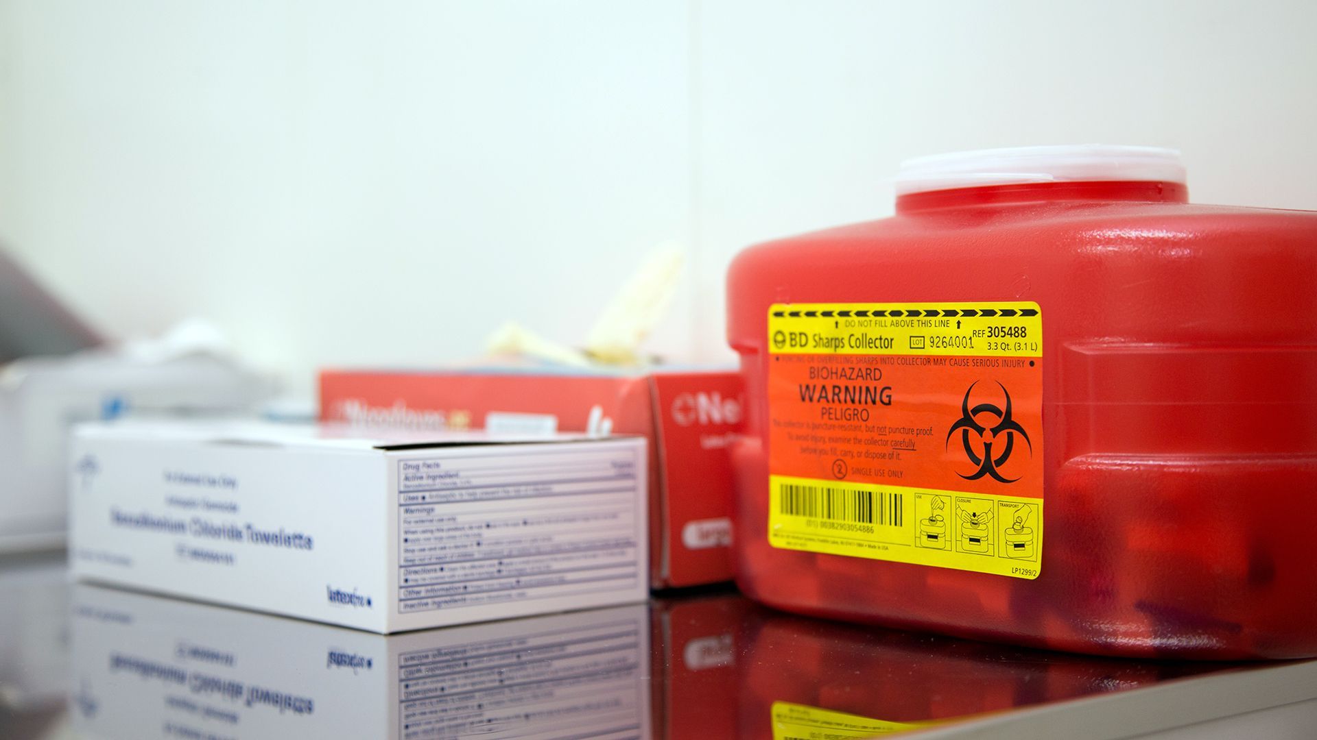 A person carrying a medical waste bag to the disposal area