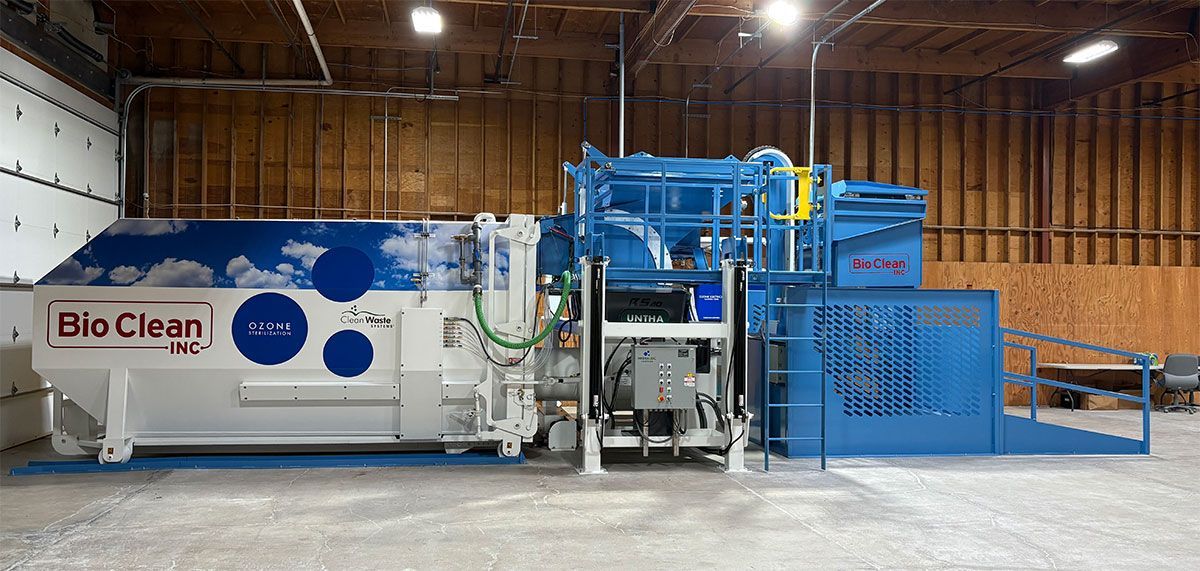 A large industrial BioClean machine with a blue and white exterior, situated on a concrete floor in a warehouse setting.