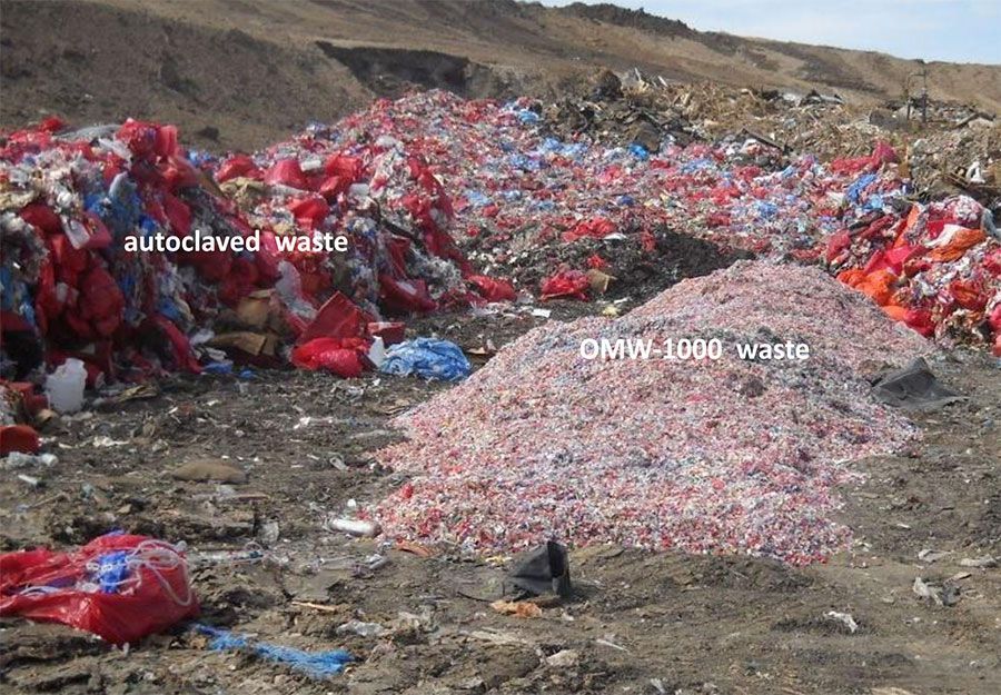A pile of autoclaved medical waste and shredded bio-hazardous waste at an outdoor disposal site.