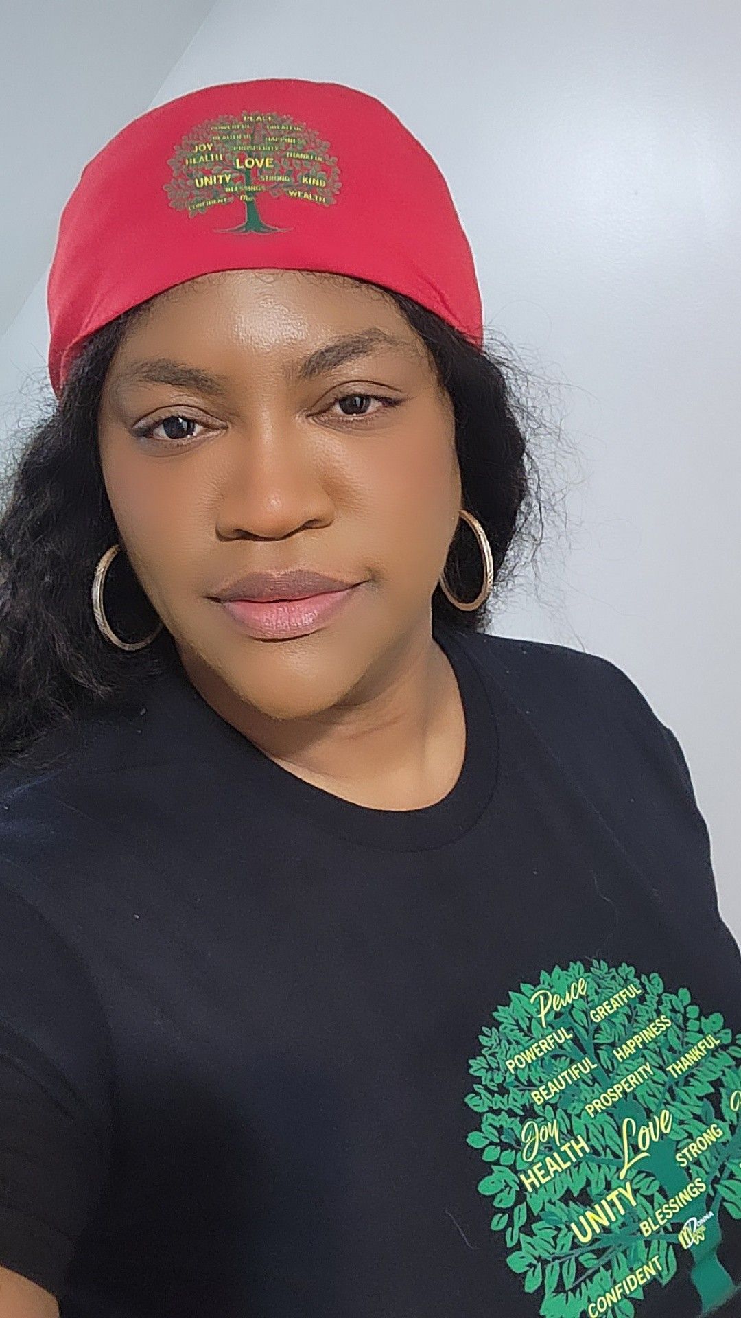 Woman in red cap and black shirt, smiling, facing the camera.