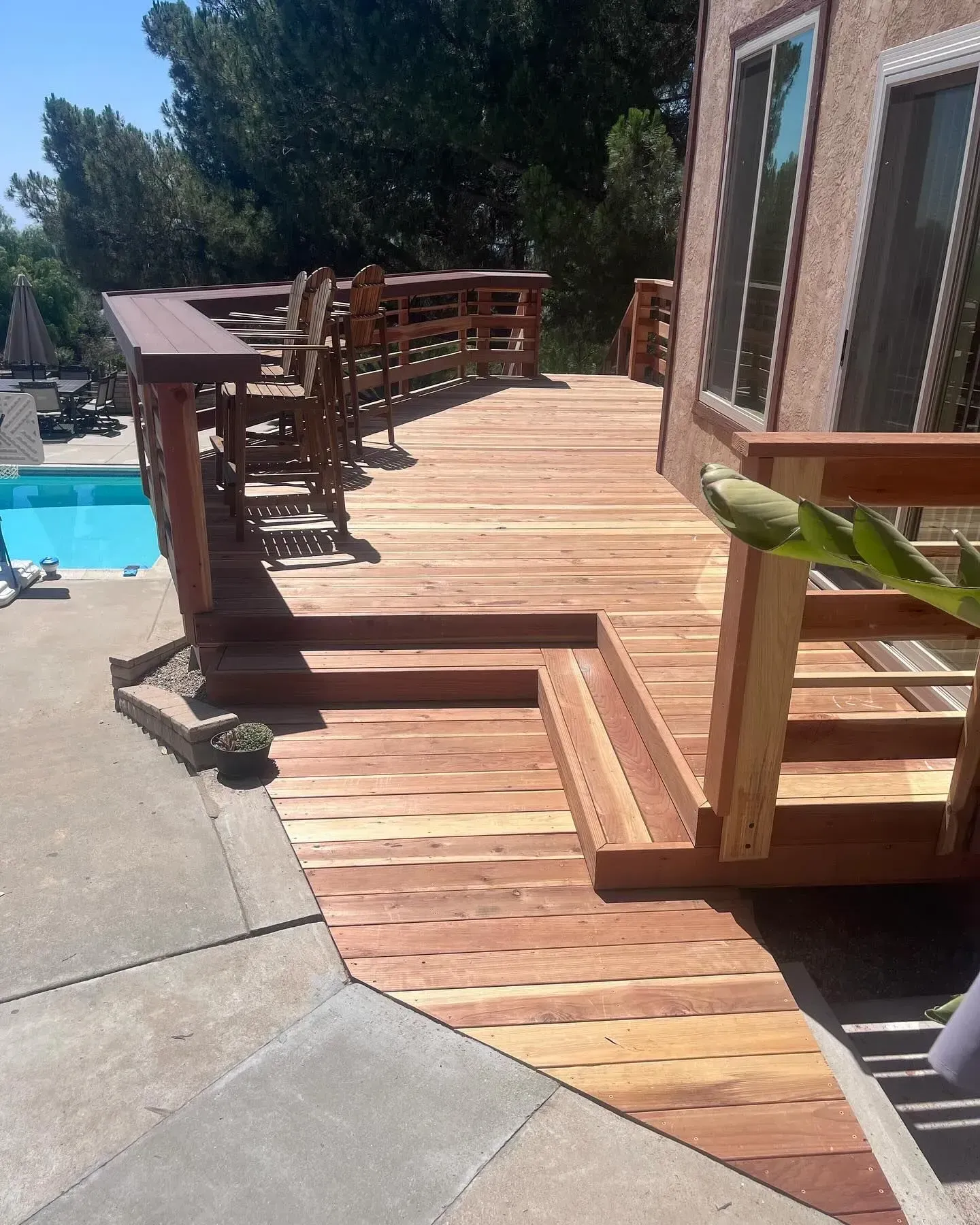 A wooden deck with stairs leading to a swimming pool