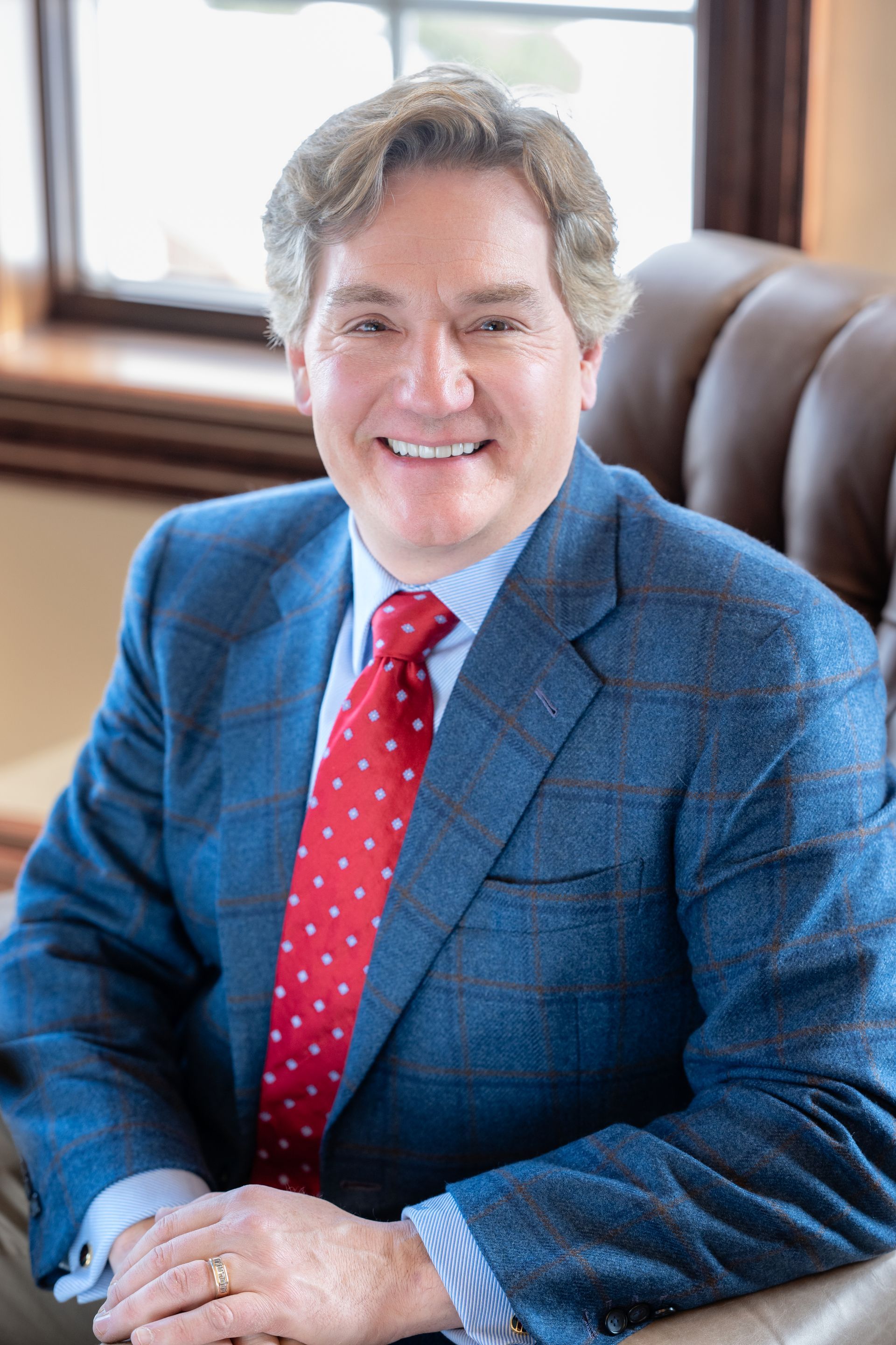 A man in a suit and tie is smiling for the camera